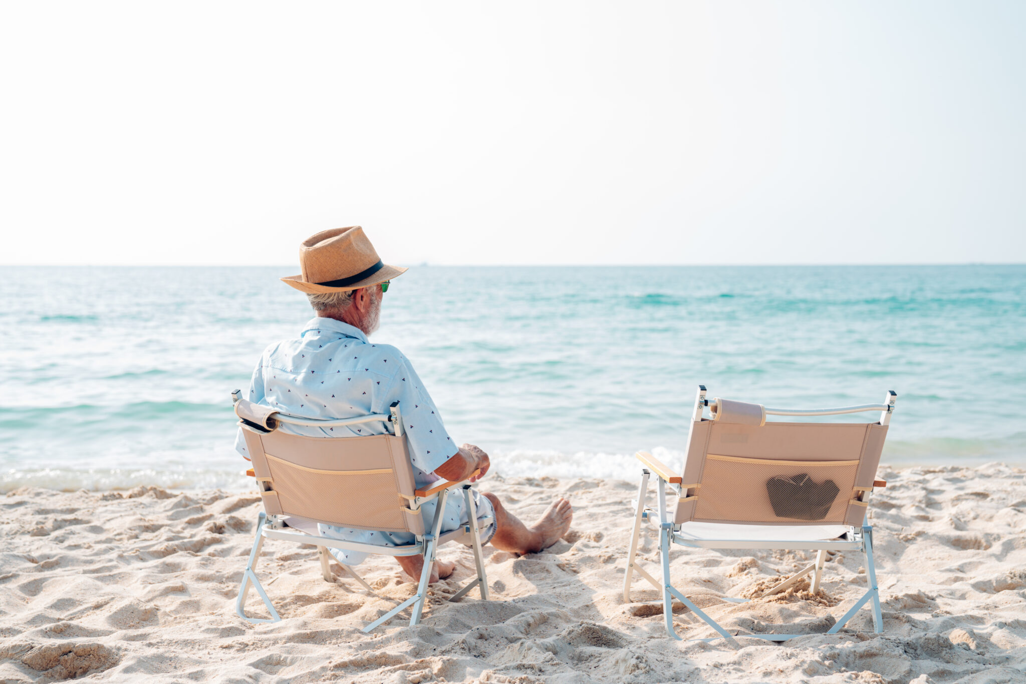happy-senior-sitting-on-a-chair-on-the-shore